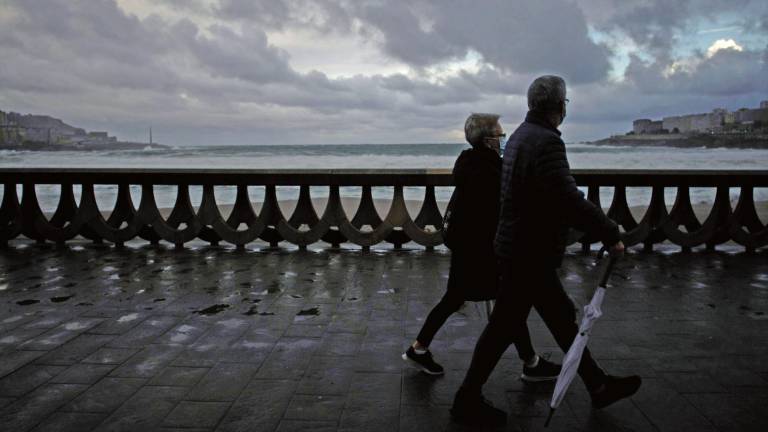 circular. Dos personas caminan durante la pasada jornada por el paseo marítimo de A Coruña. Foto: Cabalar 