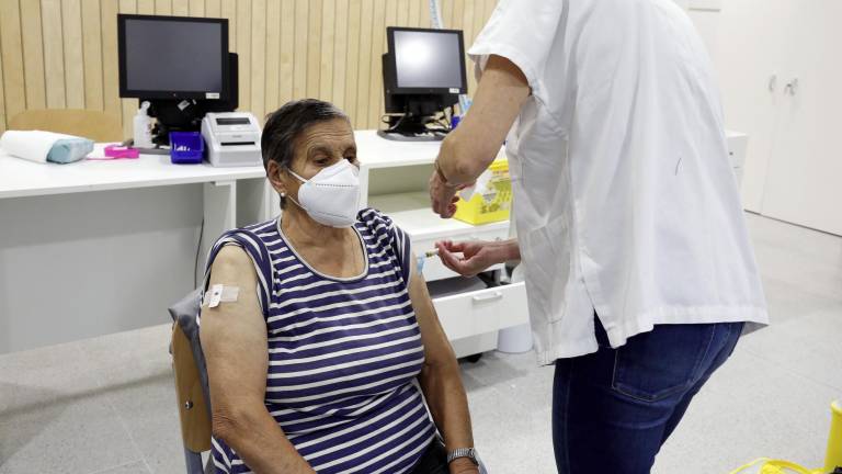 Una enfermera administra la dosis de la gripe a una mujer, en el centro de salud de O Milladoiro Foto: Antonio Hernández