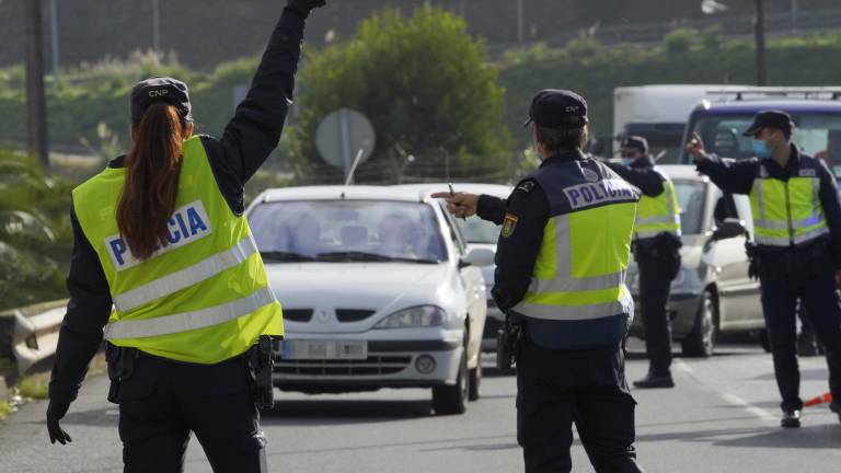 En la foto de archivo, varios agentes de la Policía Nacional dan el alto a un vehículo en un control de movilidad en la parroquia de O Castiñeiriño (Santiago de Compostela). ÁLVARO BALLESTEROS/EUROPA PRESS