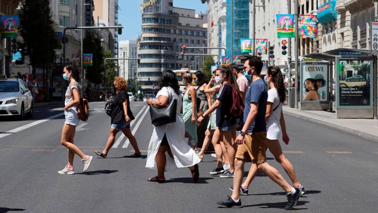 VERANO Un grupo de personas con mascarilla caminando por un de las calles céntricas de Madrid. Foto: Efe