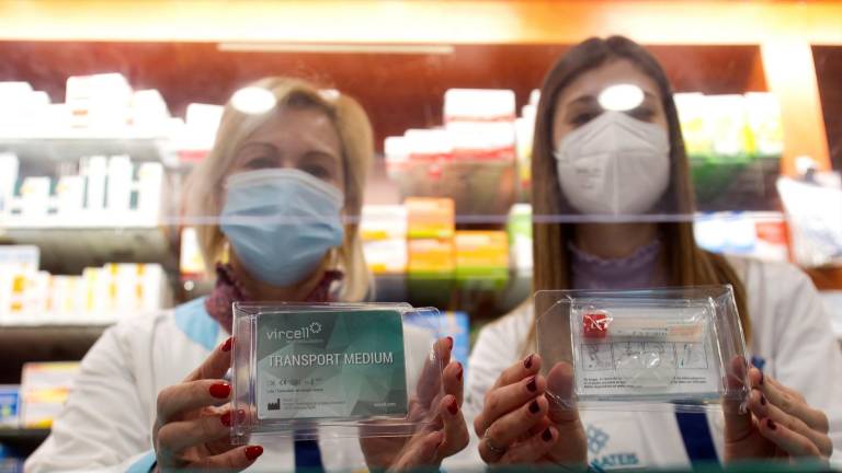 Dos farmacéuticas de un establecimiento de Vigo posan el pasado jueves con los kits para los cribados con pruebas PCR en saliva. EFE/Salvador Sas