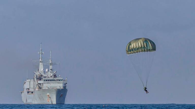 ESPECTACULARIDAD. Un paracaidista de las FGNE ante uno de los patrulleros de la Armada Española durante uno de los ejercicios realizados. Foto: A.E