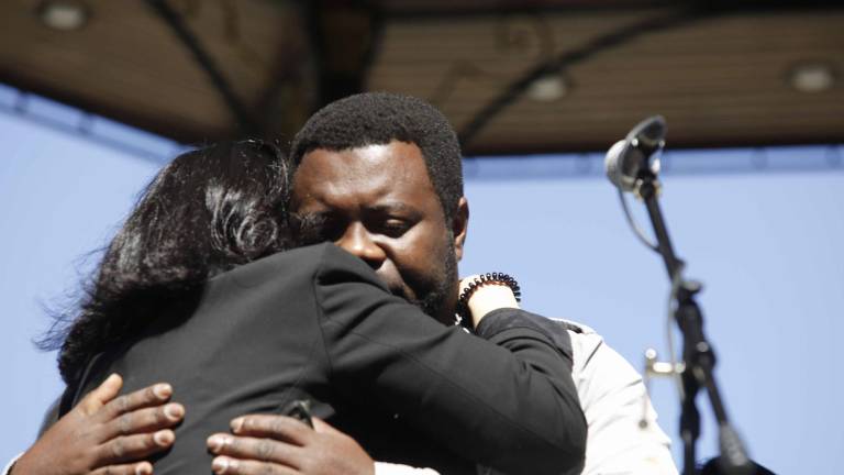 La portavoz de los familiares de los desaparecidos del naufragio, e hija de uno de ellos, María José Do Pazo, abraza a Samuel Kwesi, uno de los tres supervivientes, durante la protesta convocada el pasado domingo para pedir al Gobierno que siga buscando a las víctimas FOTO: