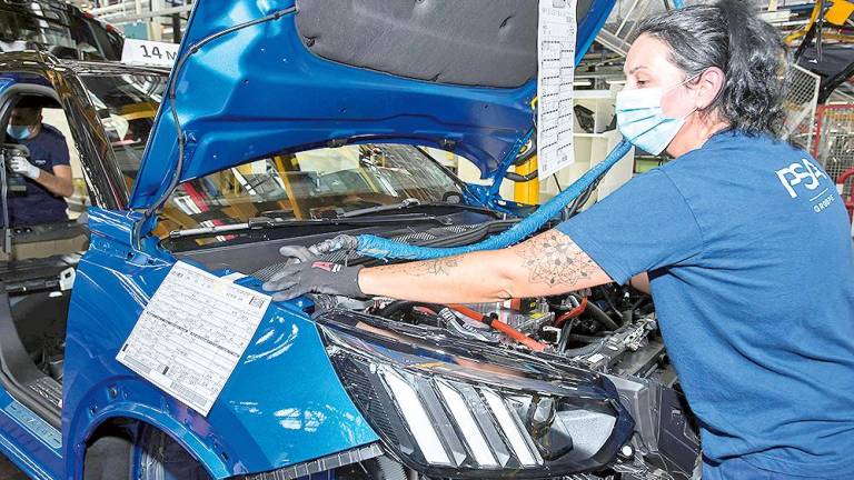 Trabajadora de la factoría viguesa del Grupo Stellantis, operando en la cadena de montaje de la automovilística.
