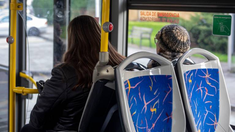 medidas. Dos personas sentadas en un autobús publico de la comunidad. Foto: Gallego