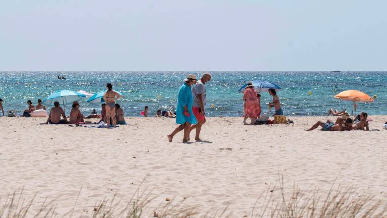 MENORCA, 28/07/2020.- Bañistas en una playa en la urbanización de Punta Prima en Menorca, este martes. Las Islas Baleares han activado el aviso naranja por temperaturas de 39 °C en el interior y sur de Mallorca, y por máximas de 37 °C en la isla de Menorca, donde los registros más altos se alcanzarán en la mitad oeste de la isla. EFE/ David Arquimbau Sintes