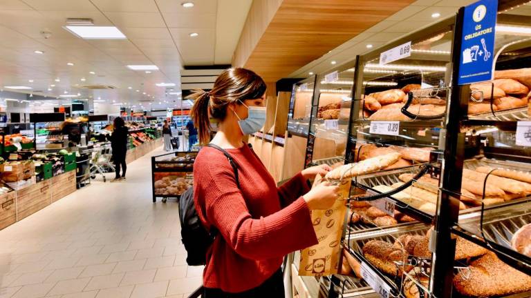 Una consumidora adquiere una barra de pan y bollería en la zona habilitada de un supermercado. Foto: Gallega