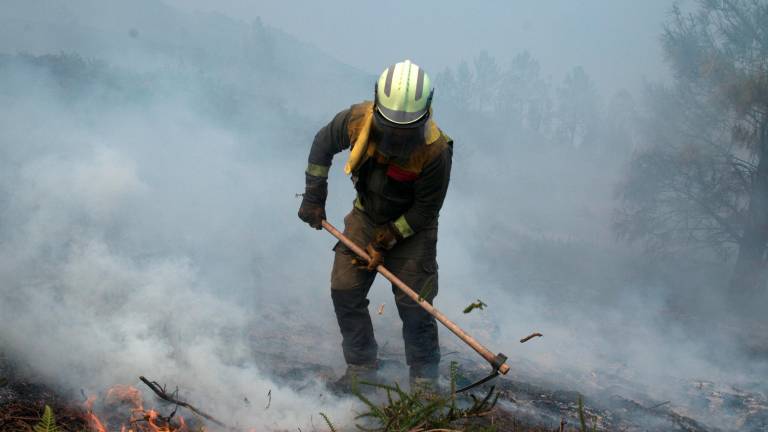 Imagen de archivo de un miembro de las brigadas contra incendios trabajando en las labores de extinción de un fuego en el Parque Natural do Xurés. Foto: Brais Lorenzo.