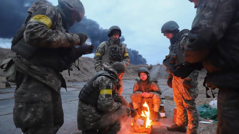 bando ucraniano. Soldados se calientan al fuego preparándose para una nueva jornada de lucha. Foto: Efe