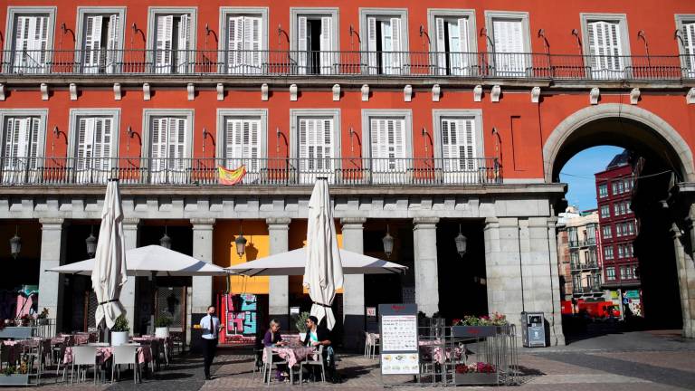 DESOLACIÓN. Las terrazas de la plaza Mayor de Madrid casi vacías al mediodía de ayer, horas antes de que entren en vigor las medidas de restricción decretadas. Foto: Chema Moya