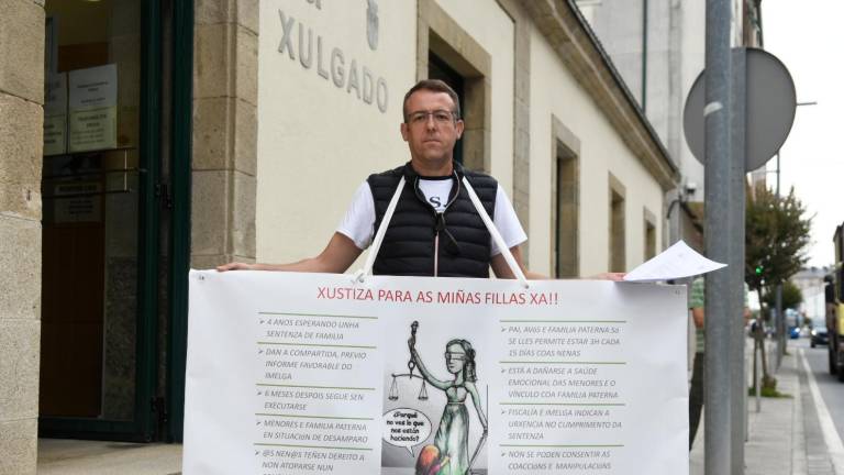 Juan Carlos Varela con la pancarta ante el Juzgado. Foto: Sangiao