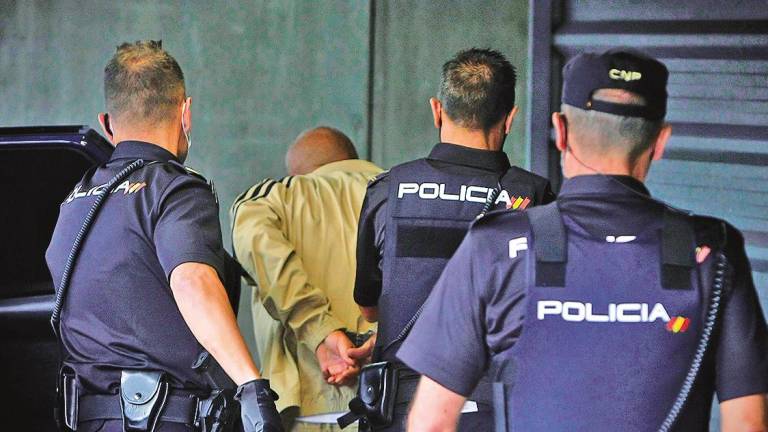 detenido es conducido por varios agentes al interior de los juzgados de A Coruña. Foto: Efe