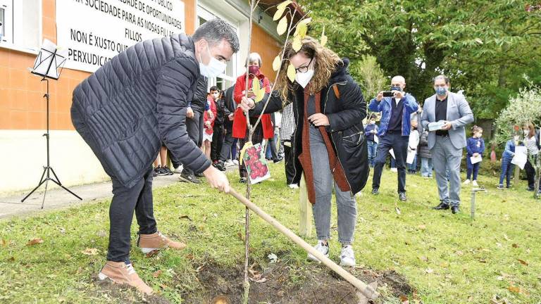 Xosé Luna planta unha cerdeira no Xardín da Poesía do colexio do Foxo con Olaya Naveira. Fotos: Puri Sangiao