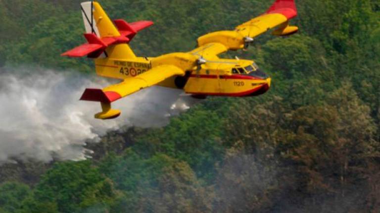 Un avión participa en las labores de extinción en un incendio en Folgoso. Foto: Efe/Eliseo Trigo
