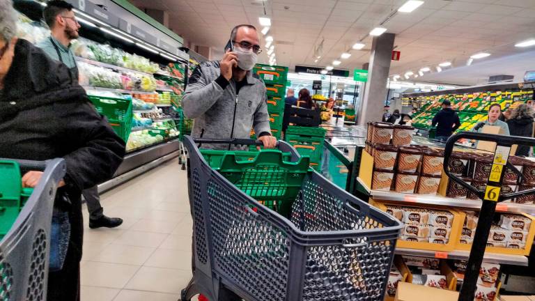 Un cliente con mascarilla se dispone a realizar su compra en una cadena de supermercados española. Foto: Efe