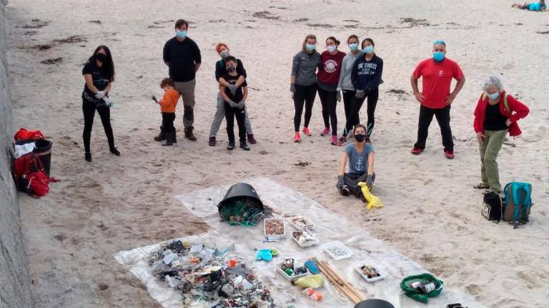 Voluntarios de una de las limpiezas promovidas por la entidad ecologista muestran la basura recogida. Foto: A.