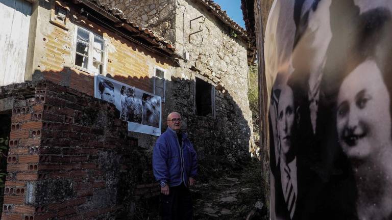 Andrés martínez, en una de las calles de Bexán, con fotos de antiguos vecinos colgadas en las fachadas de las casas Foto: Eliseo Trigo
