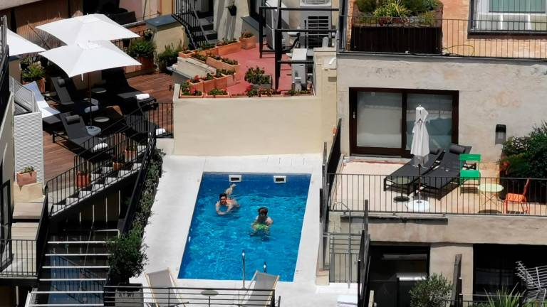 Dos bañistas disfrutan de la privilegiada ubicación de una piscina en un mar de tejados de una gran urbe. Foto: S. R.