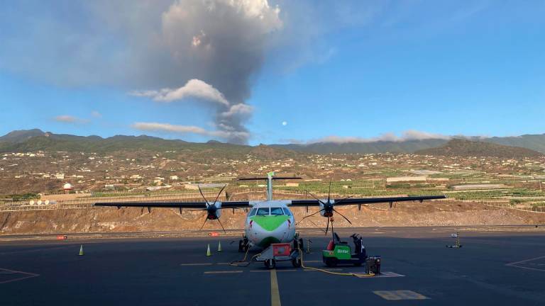 Un avión de Binter en la pista del aeropuerto de La Palma, con el volcán en erupción al fondo - BINTER