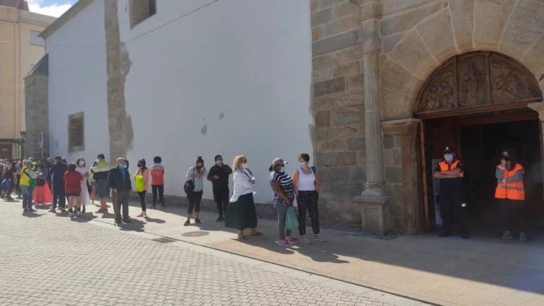 Fila de persoas esperando para entrar á igrexa parroquial de Caión. Foto: Peña Royal de Caión
