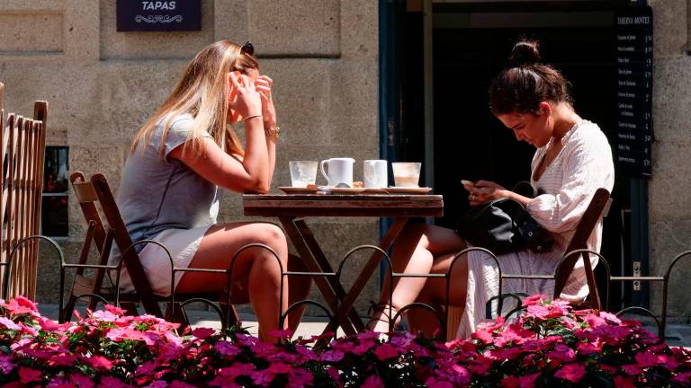 Dos mujeres en la terraza de un restaurante en Rúa da Raíña de Santiago. Foto: César Arxina / E.P.
