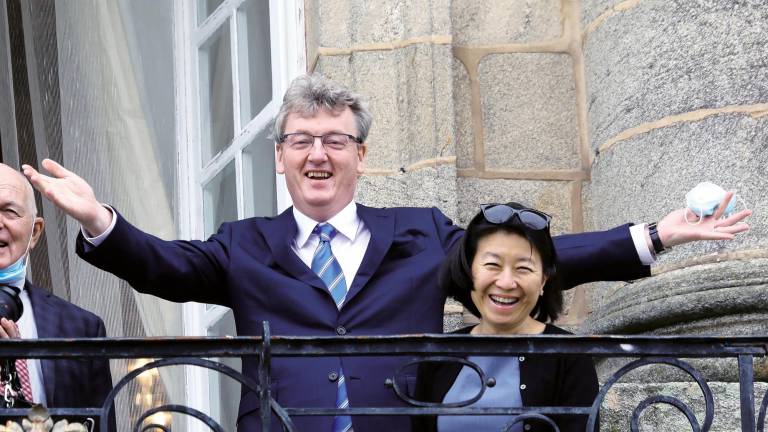El Nobel MacMillan saludando desde el balcón de Raxoi junto a su esposa. Foto: Xoán Rey/Efe