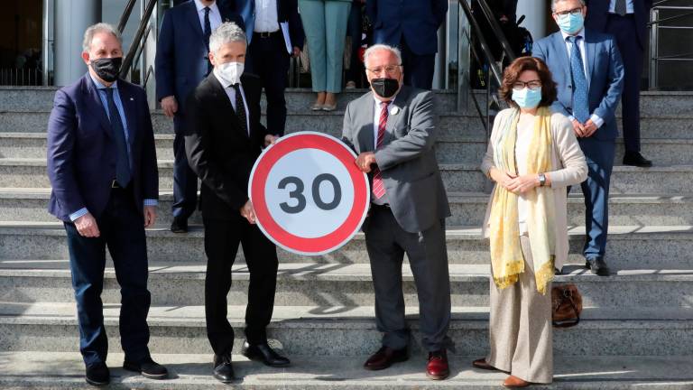 Fernando Grande-Marlaska y Pere Navarro en el centro sosteniendo la señal de limitación a 30 por hora. Foto: Europa Press