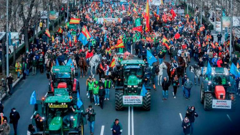 Personas a caballo con banderas de España, tractores y manifestantes en enero pasado en la movilización en defensa del campo y del mundo rural y la futura Ley de Protección Animal. FOTO: Ricardo Rubio - Europa Press