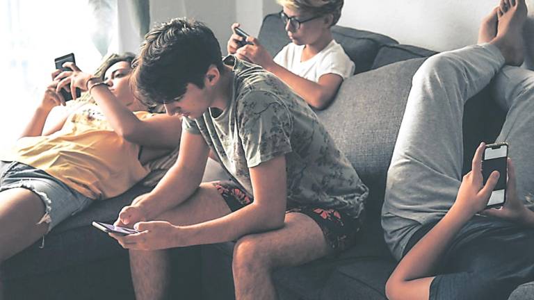 INTERNET. Grupo de adolescentes usando dispositivos móviles y redes sociales en el salón de un hogar. Foto: Europa Press
