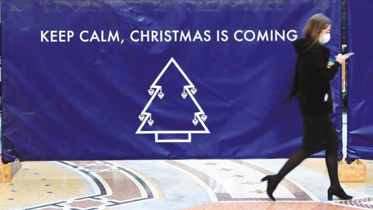 Una mujer pasa delante de un cartel que anuncia la Navidad el año pasado. Foto: Efe