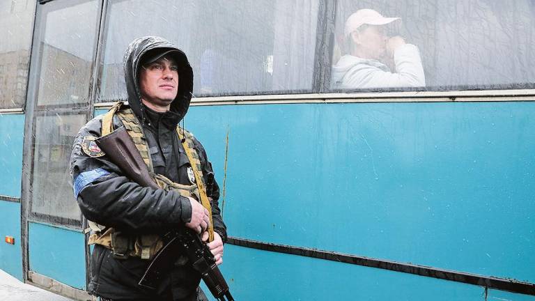 policía vigila el autobús con los residentes evacuados de Rudnytske, región de Kiev. Foto: Hennadii Minchenko 
