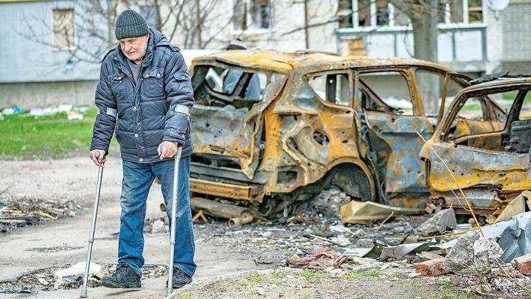 Destrozos por los bombardeos rusos en Chernihiv, donde un hombre pasa con muletas. Foto: Celestino A. Lavin 