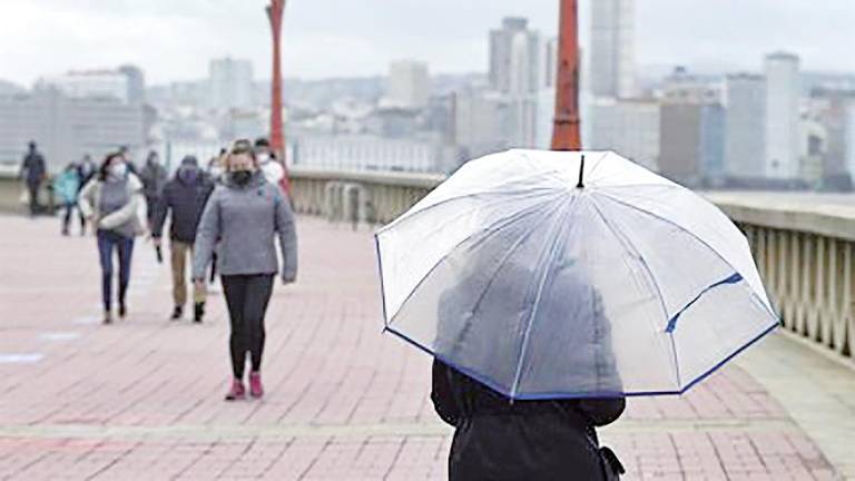 mal tiempo. Una persona camina por su paraguas por el paseo marítimo de A Coruña. Foto: M. Dylan / Europa Press Archivo