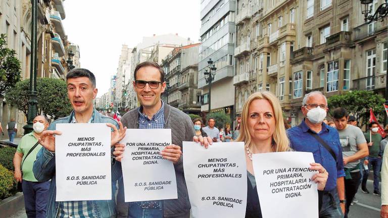 Varias personas con carteles en una manifestación en defensa de la sanidad pública del área sanitaria, que recorrió las calles de Vigo el pasado día 12 de este mes. Foto: Javier Vázquez / E. Press