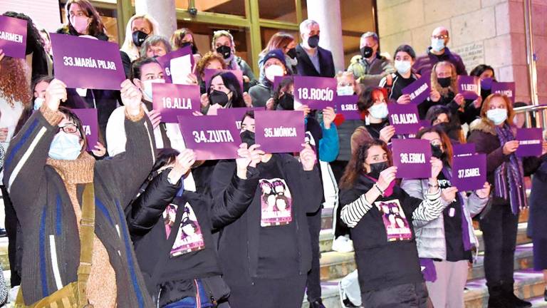 Mulleres amesás no acceso á casa do concello con carteis nos que figura o nome das asasinadas. Foto: CDA