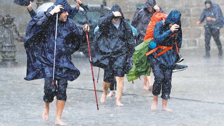 santiago de compostela. Un grupo de peregrinos terminó esta semana el Camino de Santiago bajo una lluvia torrencial en el Obradoiro. Foto: Lavandeira Jr. / Efe