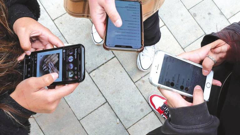 jóvenes utilizando sus teléfonos móviles para acceder a sus redes sociales, una adicción para muchos. Foto:E.press