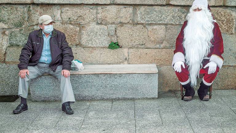 fiestas. Un hombre disfrazado de Papá Noel al lado de un ciudadano con mascarilla (Ourense). Foto: B. Lorenzo