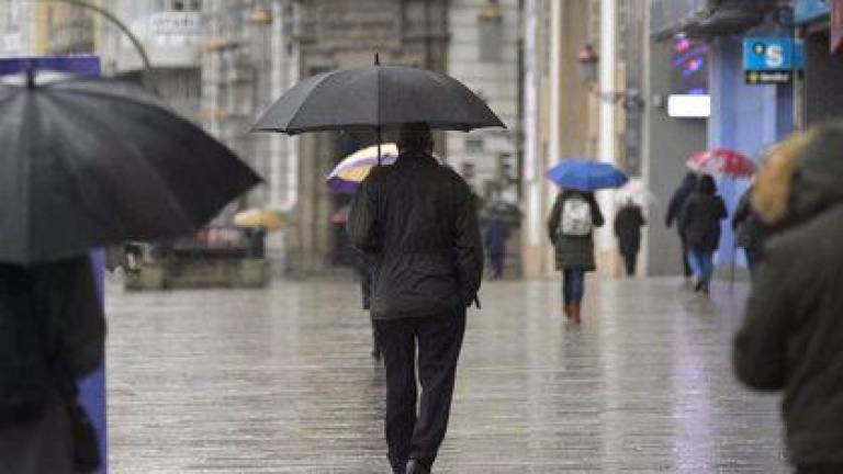 en un día de lluvia Personas caminando con paraguas por una calle de A Coruña. Foto: M.Dylan.