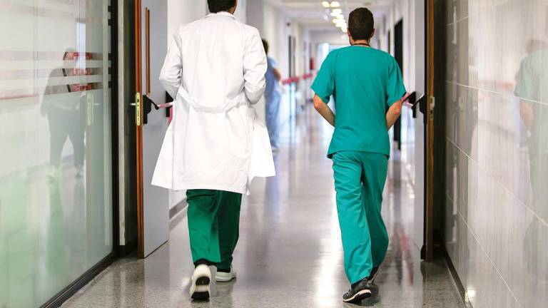 Hospital. Dos sanitarios caminan por el pasillo de un centro hospitalario. Foto: Gallego