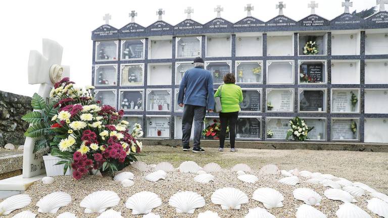 Una pareja ante las tumbas de un cementerio rural de Área de Compostela. Foto: Lavandeira JR