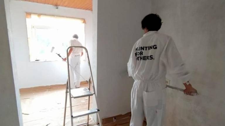 Dous voluntarios da iniciativa solidaria ‘Paiting for others’ pintando as paredes. Foto: C.A.