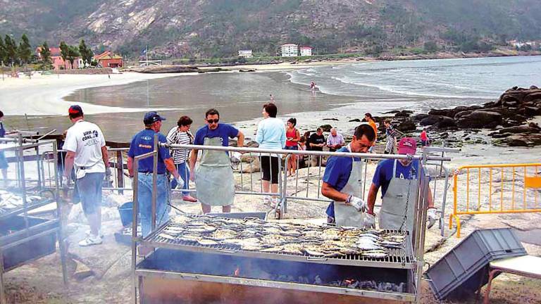 Miembros de la organización hacen la sardiñada en una edición anterior de la Festa da Praia