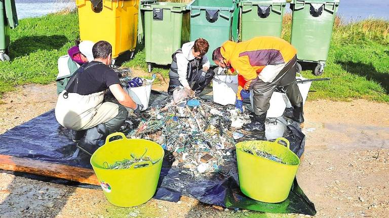 Mariscadores e técnicos da asociación de Baldaio clasificando o lixo recollido. Foto: C. C.
