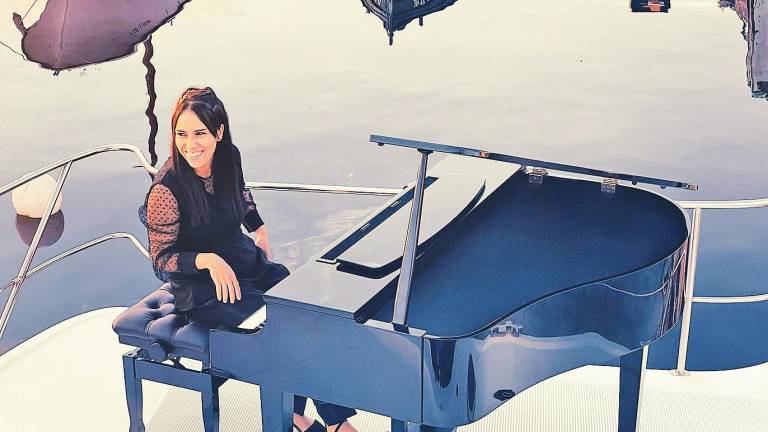 corenta millas. Elsa Muñiz, sentada ó piano no barco no que percorre 40 millas náuticas. Foto: Octo C.
