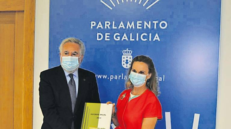 MÁS ACTIVIDAD. María Dolores Fernández Galiño entrega a Miguel Santalices el Informe Anual 2020 del Valedora do Pobo, con la actuación el pasado año. Foto: Parlamento