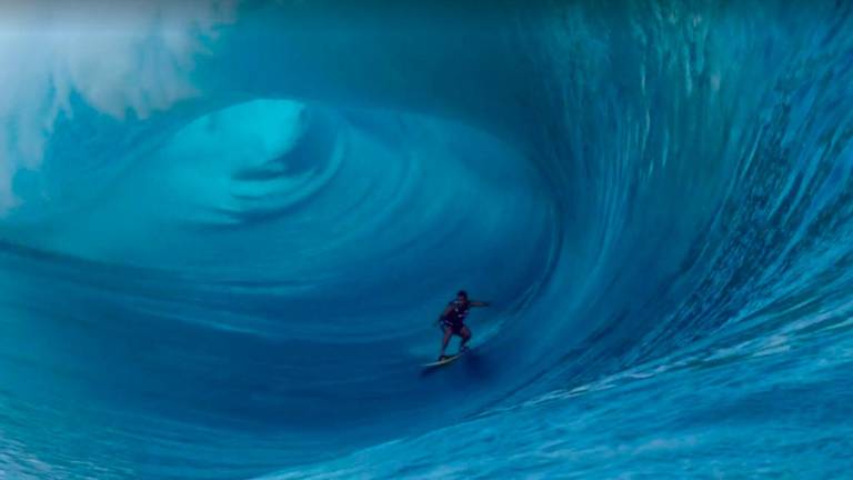 <b>Town-in surfing</b>. Para poder <i>surfear</i> estas olas de más de ocho metros te han de remolcar hasta el pico de la misma. Es la modalidad más peligrosa de este deporte. (Imagen, <u>theinertia.com)</u>