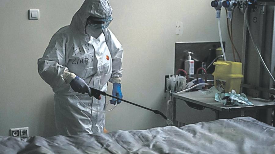 protección. Una trabajadora desinfecta una camilla en el interior de la unidad de vigilancia posquirúrgica (Ourense). Foto: Brais Lorenzo