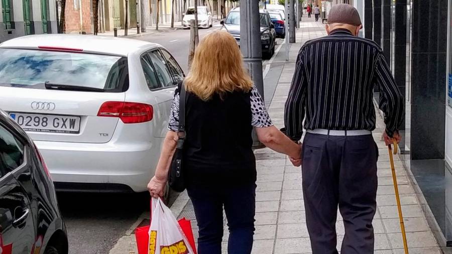 Una pareja de personas mayores transita por una calle de Monforte de Lemos Foto: Angar