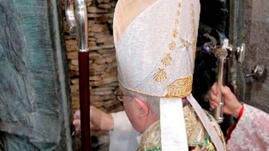 Monseñor Julián Barrio en la apertura de la Puerta Santa el 31 de diciembre de 2009. A la derecha, el ceremoniero de entonces le facilitaba el martillo de plata para derribar el muro